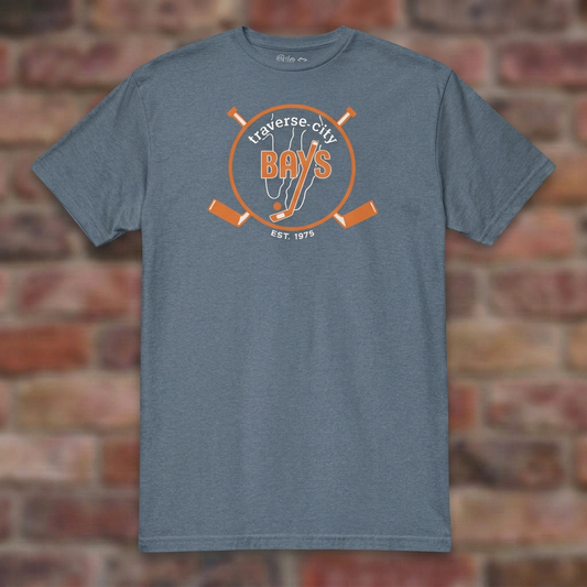 Traverse City Bays Hockey Heather Indigo T-shirt flat lay on brick background