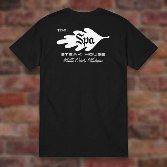 The Spa Steak House Black T-shirt flat lay on brick background