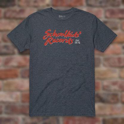 Schoolkids Records Ann Arbor T-shirt in Heather Navy, flat lay on warm brick background