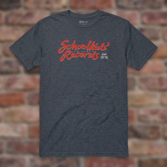 Schoolkids Records Ann Arbor T-shirt in Heather Navy, flat lay on warm brick background