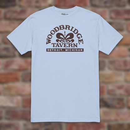 Woodbridge Tavern Light Blue T-shirt flat lay on brick background