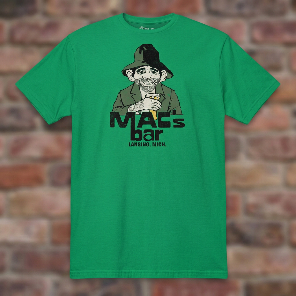 Irish Green Mac's Bar Lansing T-shirt flat-lay against weathered brick