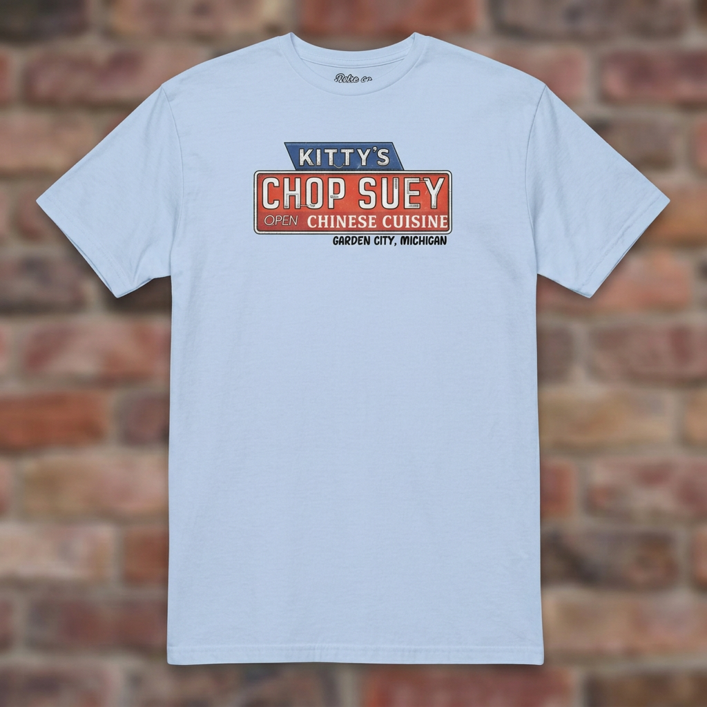 Kitty's Chop Suey Light Blue T-shirt flat lay on brick background