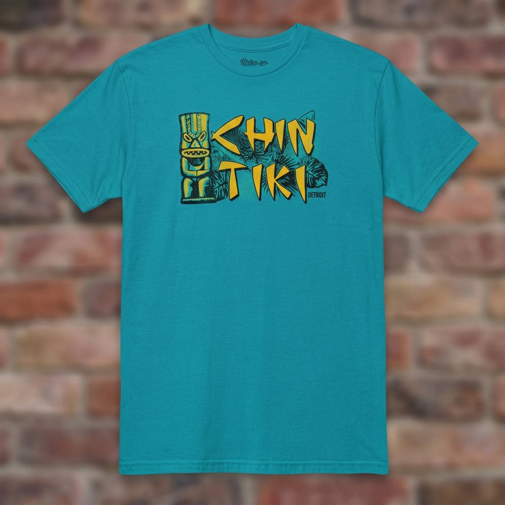 Chin Tiki Tropical Blue T-shirt flat lay on brick background