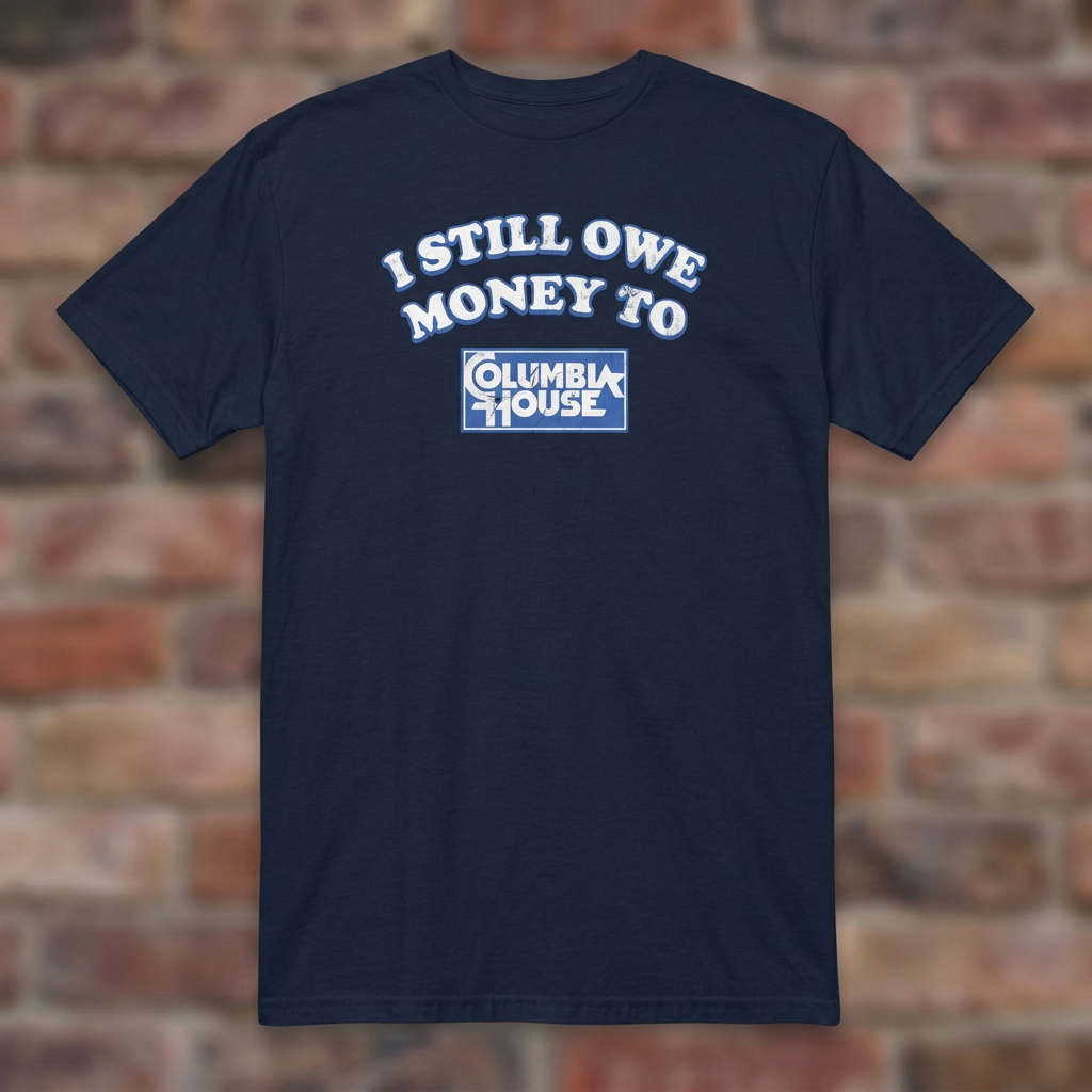 I Still Owe Money To Columbia House Navy T-shirt flat lay on brick background