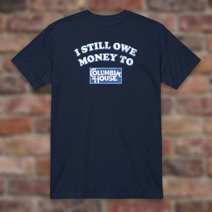 I Still Owe Money To Columbia House Navy T-shirt flat lay on brick background