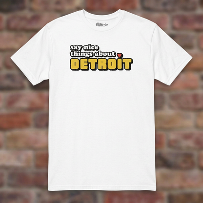 Say Nice Things About Detroit White T-shirt flat lay on brick background