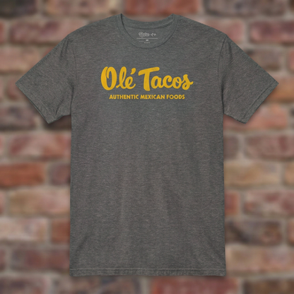 Ole Tacos Graphite Heather T-shirt flat lay on brick background