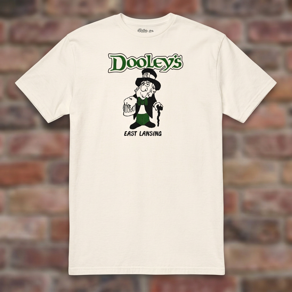 Natural Dooley's East Lansing T-shirt flat-lay against weathered brick