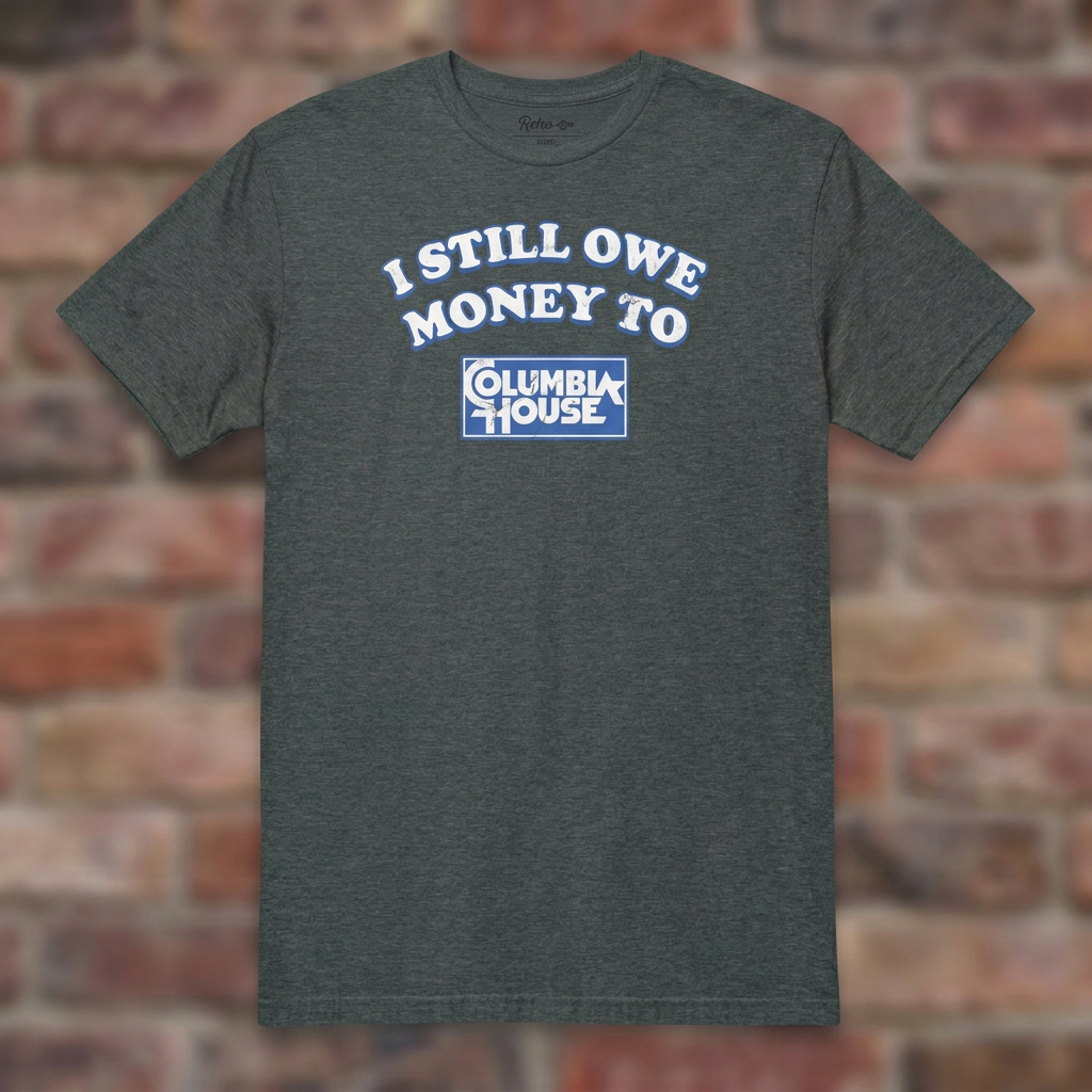 I Still Owe Money To Columbia House Dark Heather T-shirt flat lay on brick background