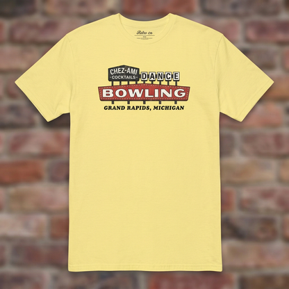 Chez-Ami Lanes Cornsilk T-shirt flat lay on brick background