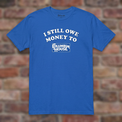 I Still Owe Money To Columbia House Royal T-shirt flat lay on brick background