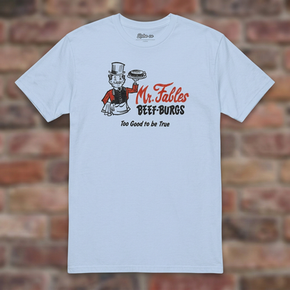 Light Blue Mr. Fables T-shirt flat lay on warm brick