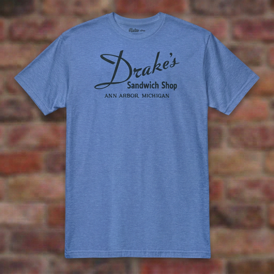 Drake's Sandwich Shop Heather Royal T-shirt flat lay on brick background