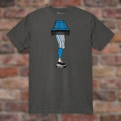 Dark Heather Grey Detroit Football Leg Lamp T-shirt flat-lay against weathered brick