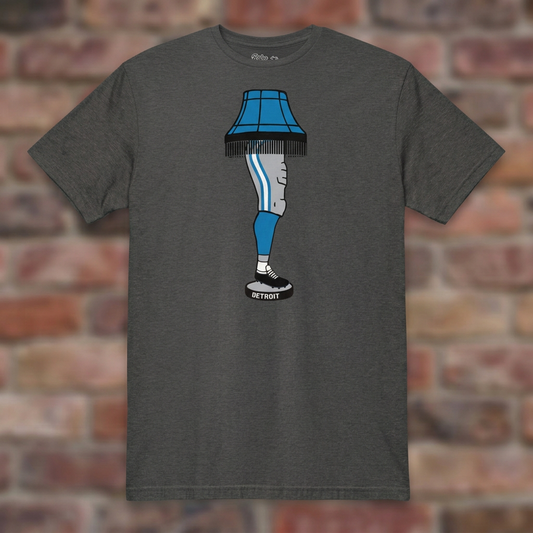 Dark Heather Grey Detroit Football Leg Lamp T-shirt flat-lay against weathered brick