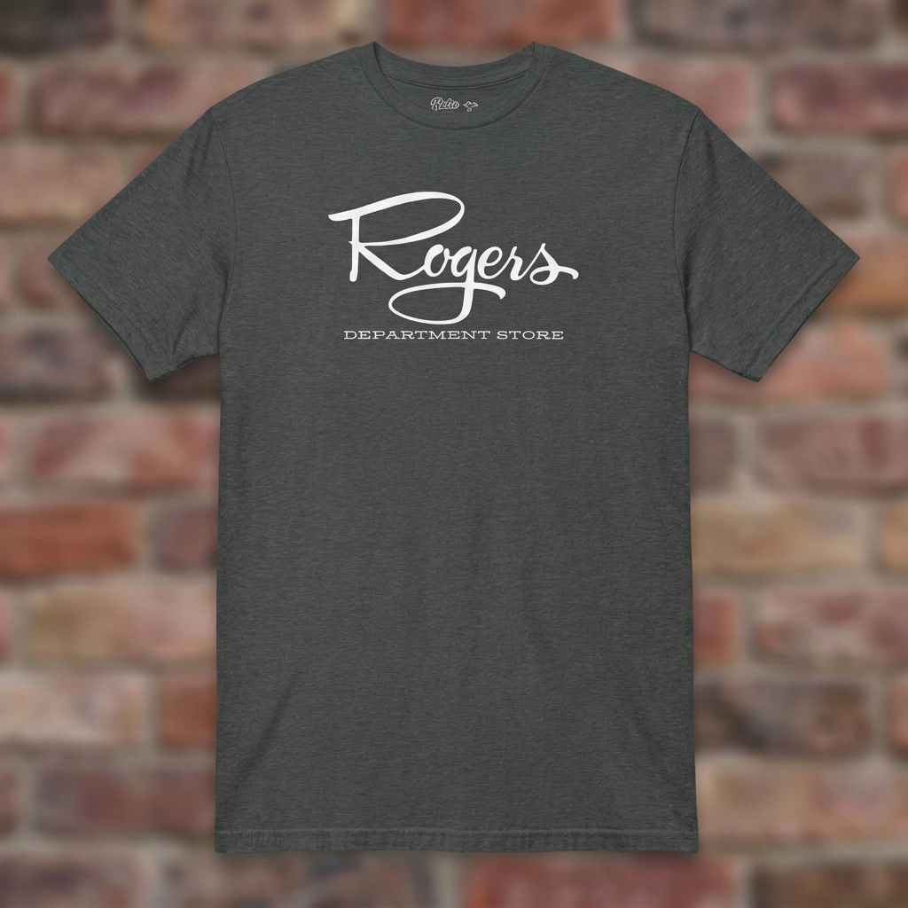 Roger's Department Store T-shirt in Dark Heather Grey, flat lay on warm brick background