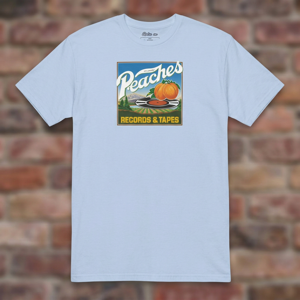Peaches Records & Tapes Light Blue T-shirt flat lay on brick background