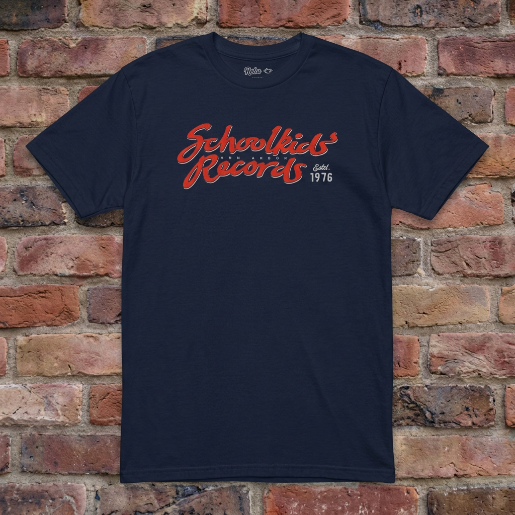 Schoolkids Records Ann Arbor T-shirt in Navy, flat lay on warm brick background