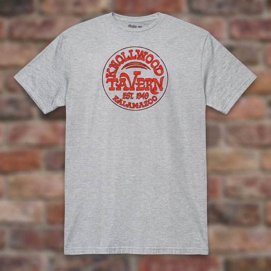 Sport Grey Knollwood Tavern Kalamazoo T-shirt flat-lay against weathered brick