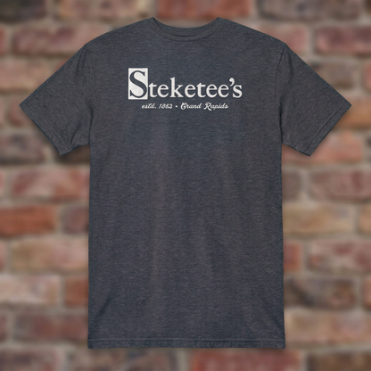 Steketee's Heather Navy T-shirt flat lay on brick background