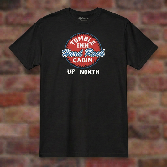 Tumble Inn Hard Rock Cabin Black T-shirt flat lay on brick background