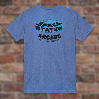 Space Station Arcade Heather Royal T-shirt flat lay on brick background
