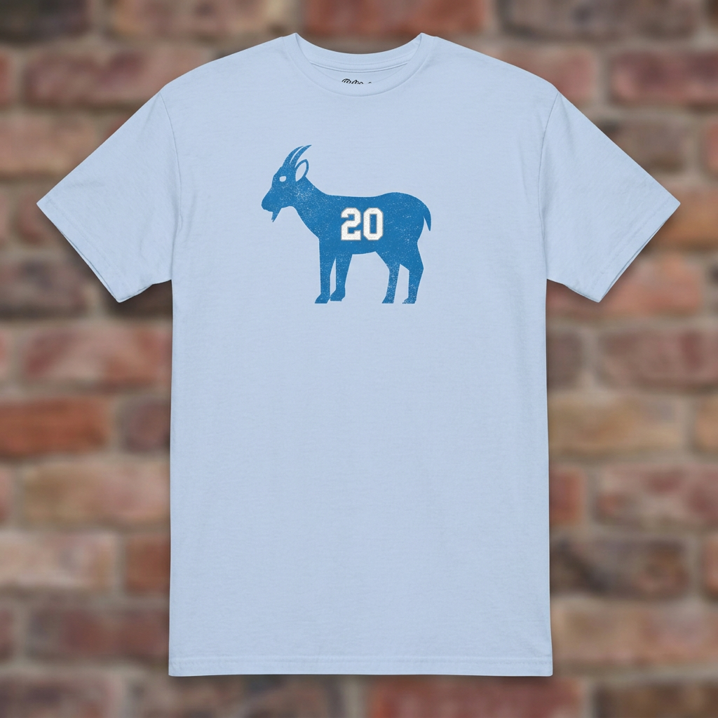 GOAT Barry Light Blue T-shirt flat lay on brick background