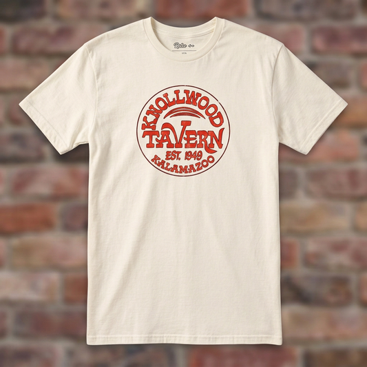 Natural Knollwood Tavern Kalamazoo T-shirt flat-lay against weathered brick