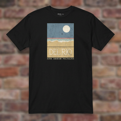 Del Rio Ann Arbor Black T-shirt flat lay on brick background