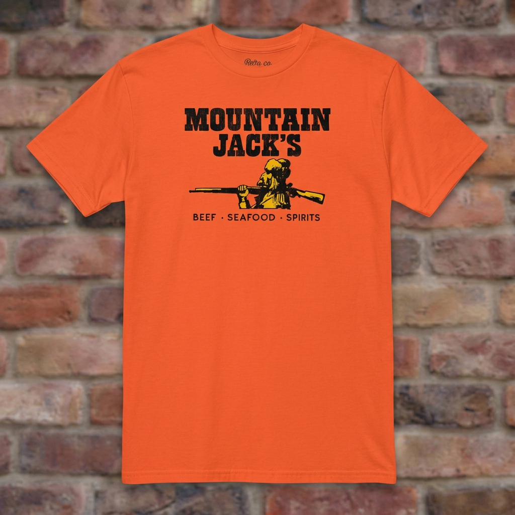 Mountain Jack's Orange T-shirt flat lay on brick background