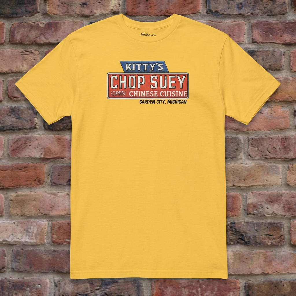 Kitty's Chop Suey Daisy T-shirt flat lay on brick background