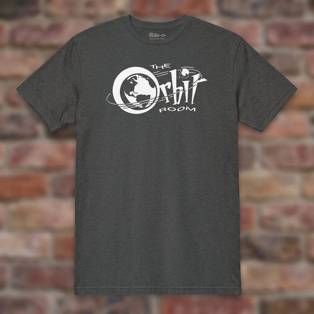 The Orbit Room Dark Heather Grey T-shirt flat lay on weathered brick background