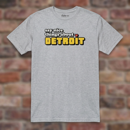 Say Nice Things About Detroit Sport Grey T-shirt flat lay on brick background