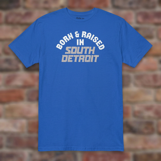 Born & Raised in South Detroit Royal T-shirt flat lay on brick background