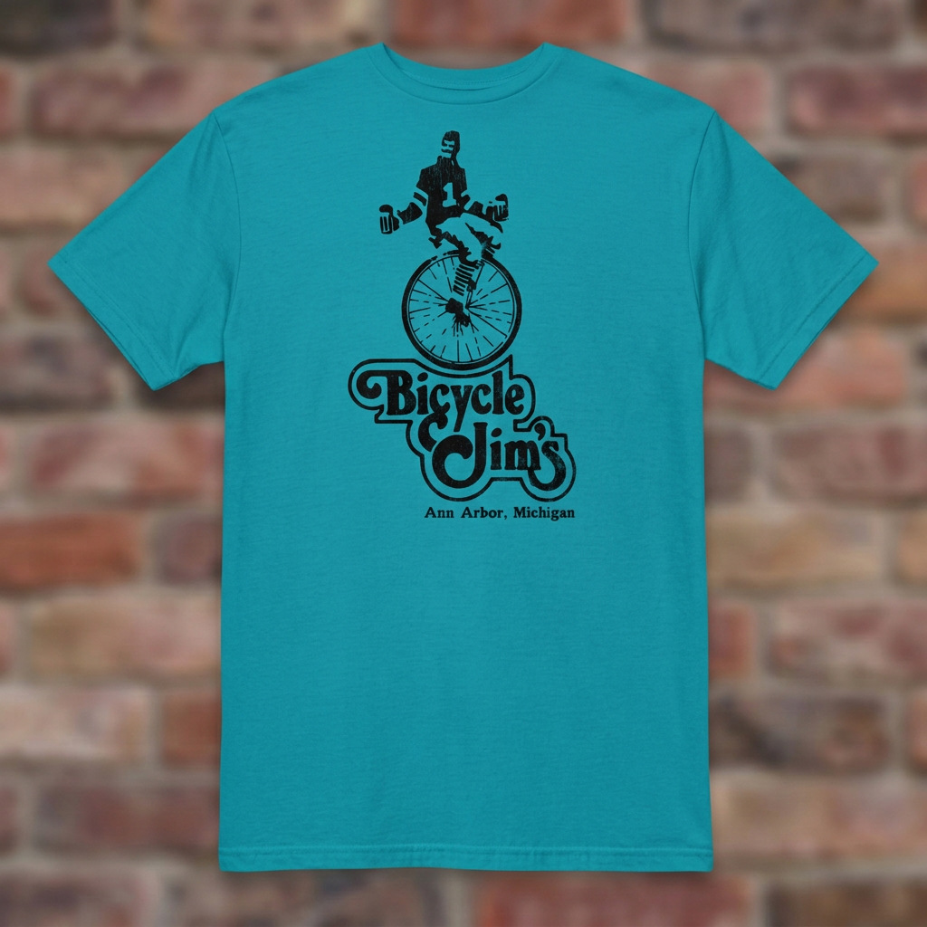 Bicycle Jim's Tropical Blue T-shirt flat lay on brick background