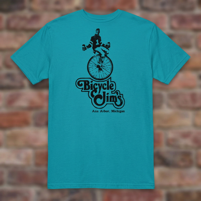 Bicycle Jim's Tropical Blue T-shirt flat lay on brick background