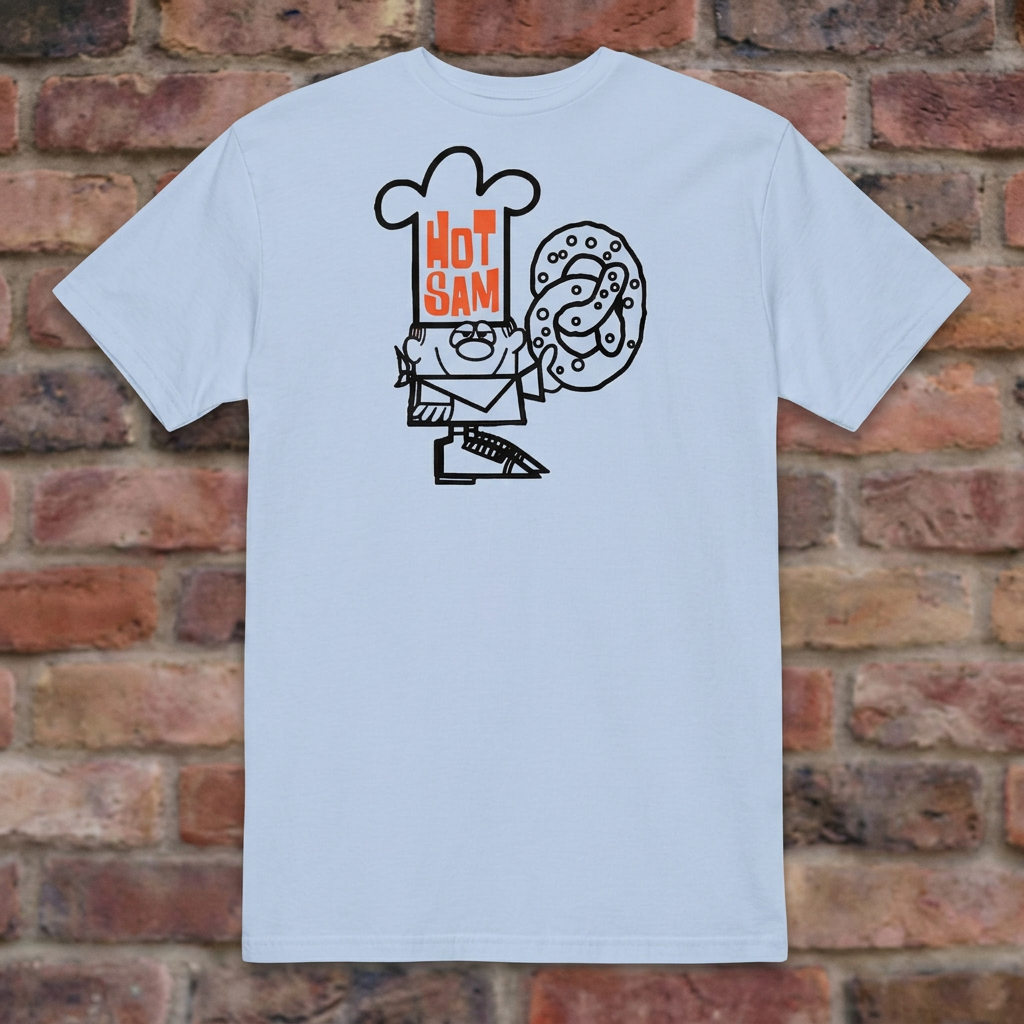 Hot Sam Pretzels T-shirt in Light Blue, flat lay on warm brick background