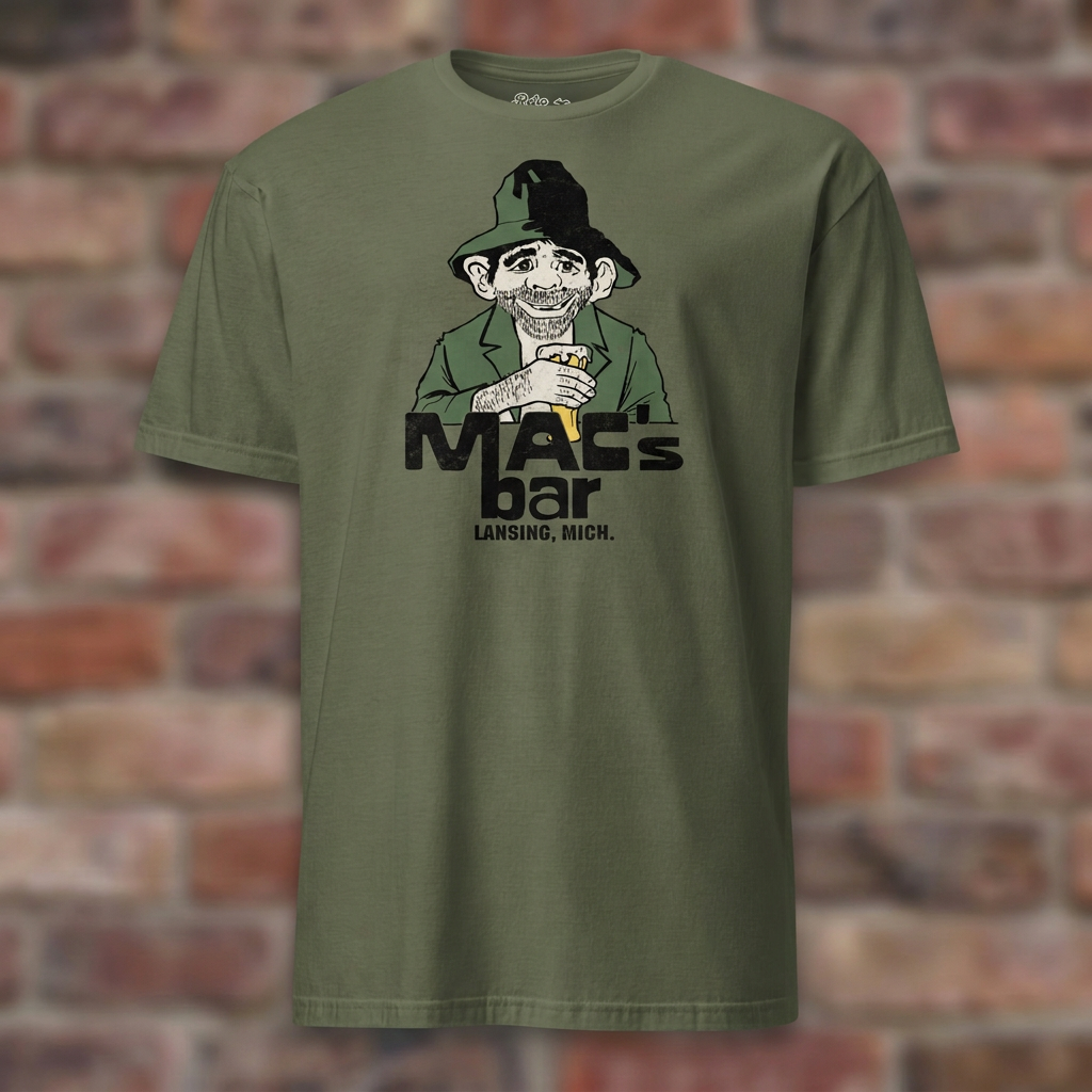 Military Green Mac's Bar Lansing T-shirt flat-lay against weathered brick