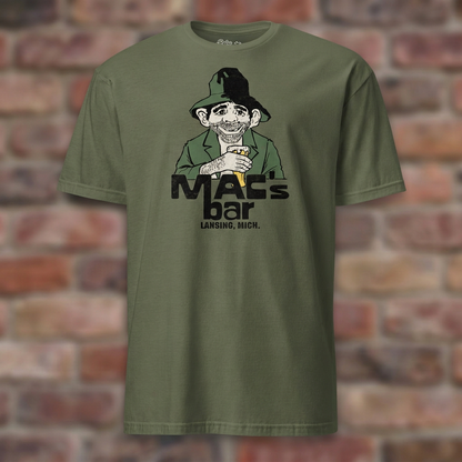 Military Green Mac's Bar Lansing T-shirt flat-lay against weathered brick