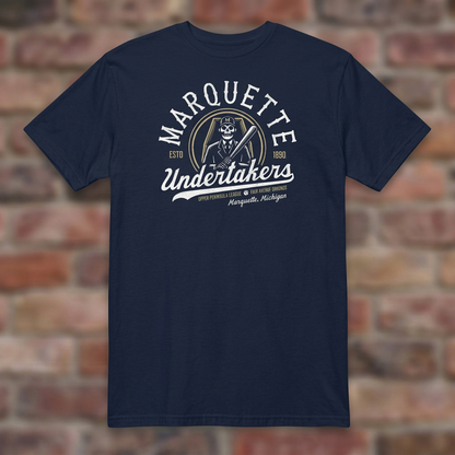 Marquette Undertakers Navy T-shirt flat lay on brick background