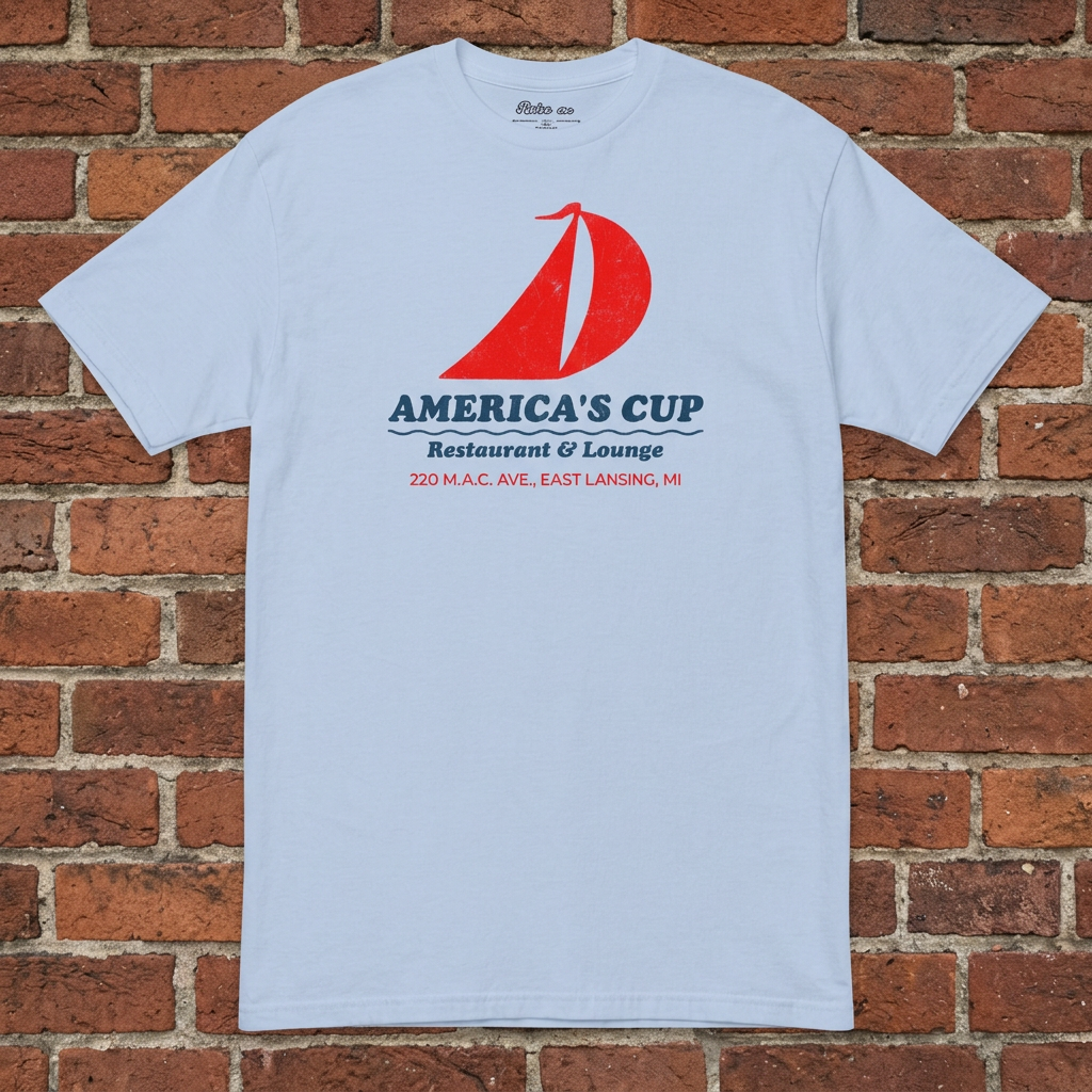 America's Cup Light Blue T-shirt flat lay on brick background