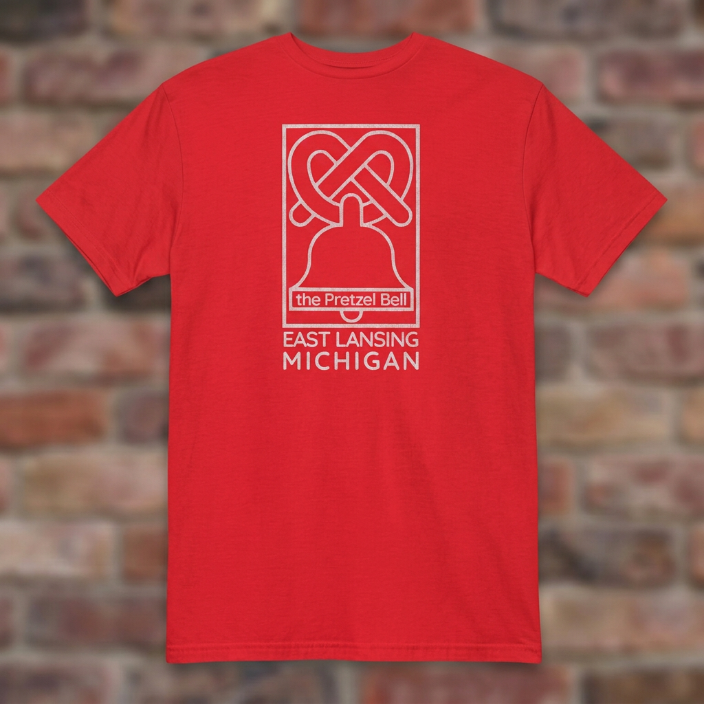 The Pretzel Bell East Lansing Red T-shirt flat lay on brick background