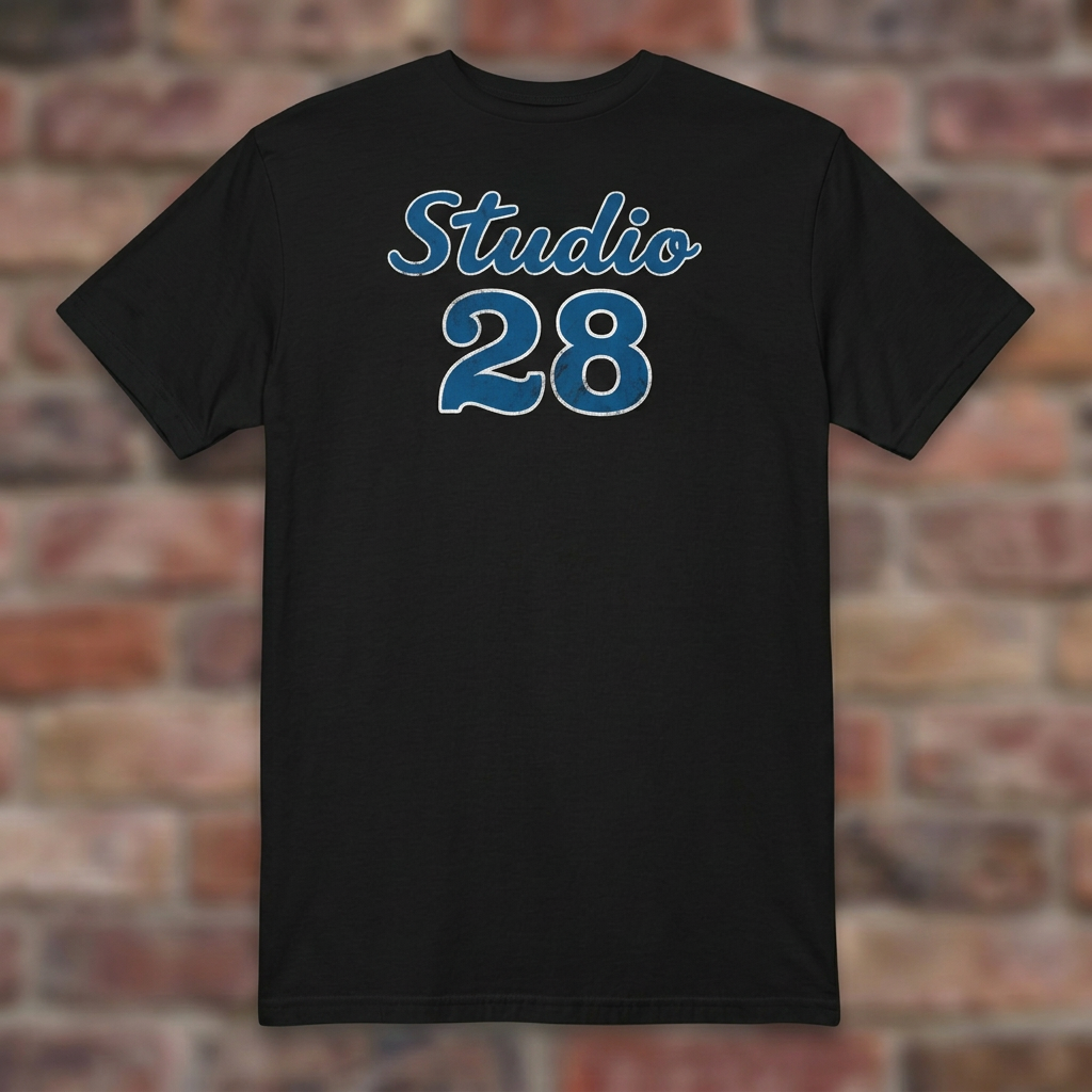 Studio 28 Black T-shirt flat lay on brick background
