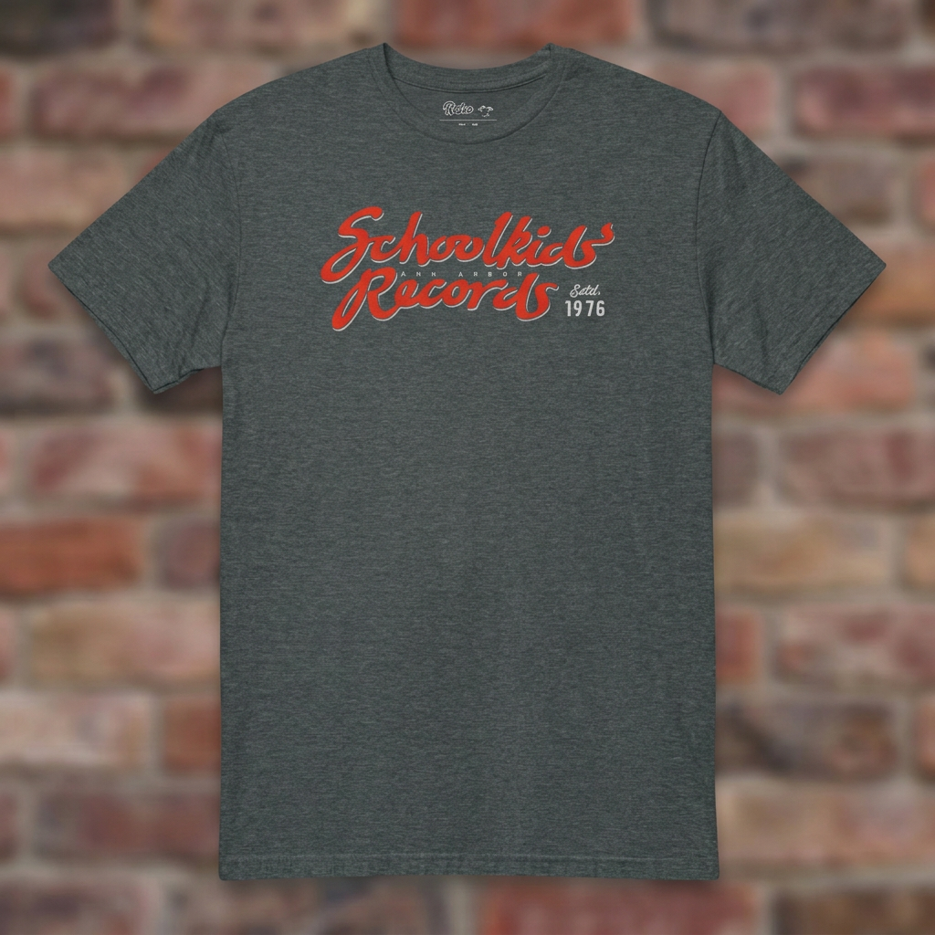 Schoolkids Records Ann Arbor T-shirt in Dark Heather, flat lay on warm brick background