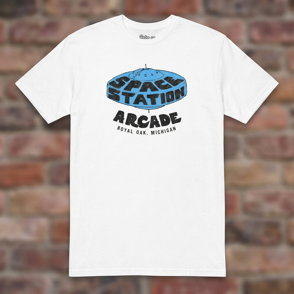 Space Station Arcade White T-shirt flat lay on brick background