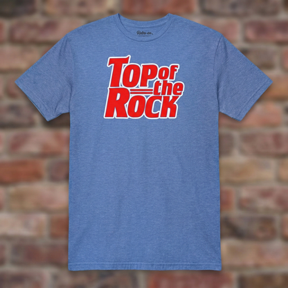 Top of the Rock Heather Royal T-shirt flat lay on brick background