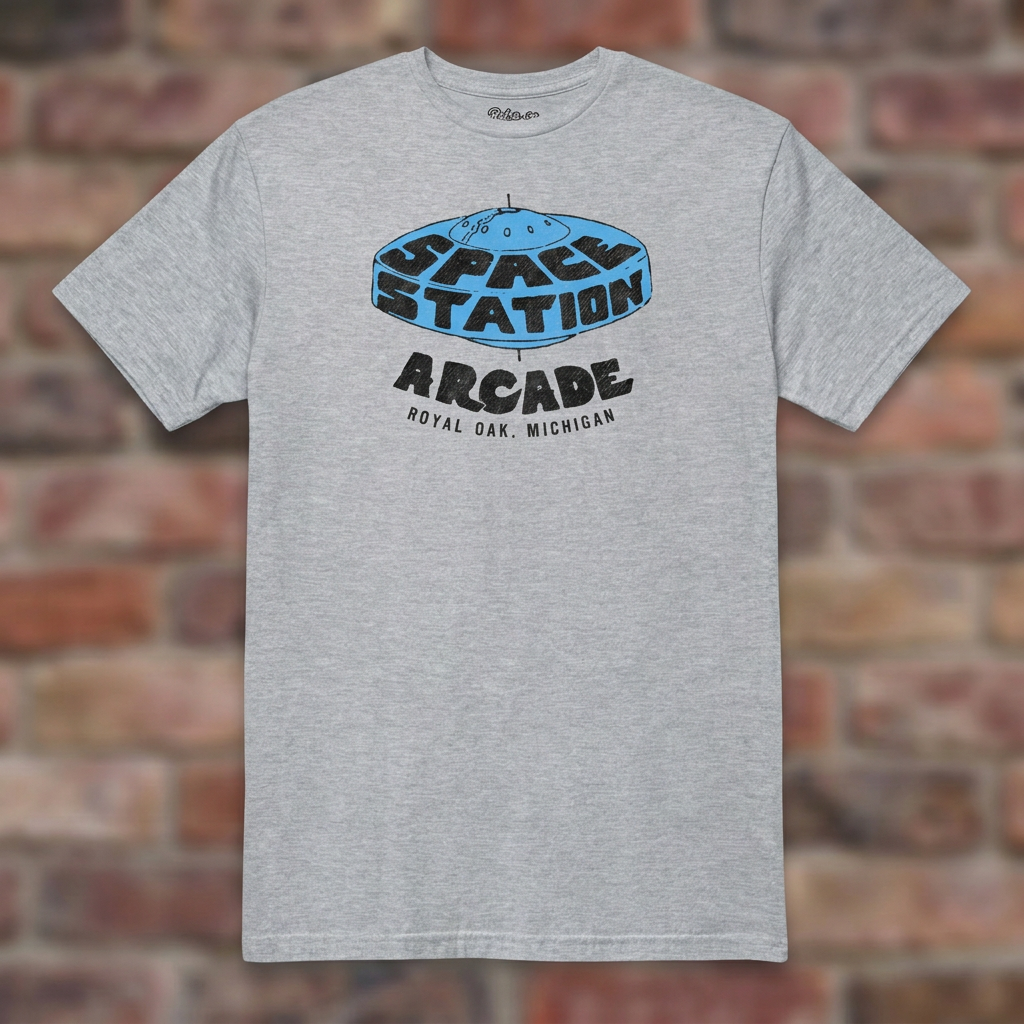 Space Station Arcade Sport Grey T-shirt flat lay on brick background