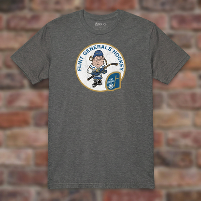 Flint Generals Hockey T-shirt in Graphite Heather, flat lay on warm brick background