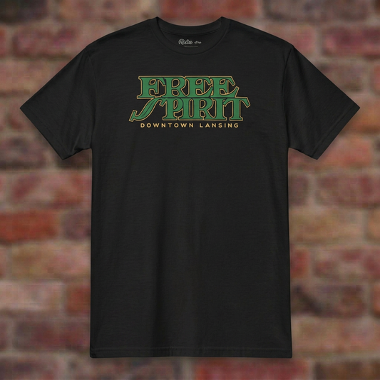 Free Spirit Downtown Lansing Black T-shirt flat lay on brick background